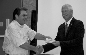 Dave Grundies (r), regional vice president, receives a $5,000 donation to the AFCEA International Educational Foundation scholarship foundation from Marty Paulsen, chapter vice president for education, in July.